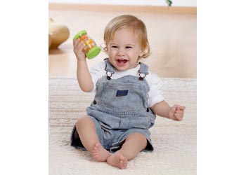 Cute picture of smiling baby holding green Halilit Tube Shaker. It makes an entertaining sound for kids like a rainmaker.